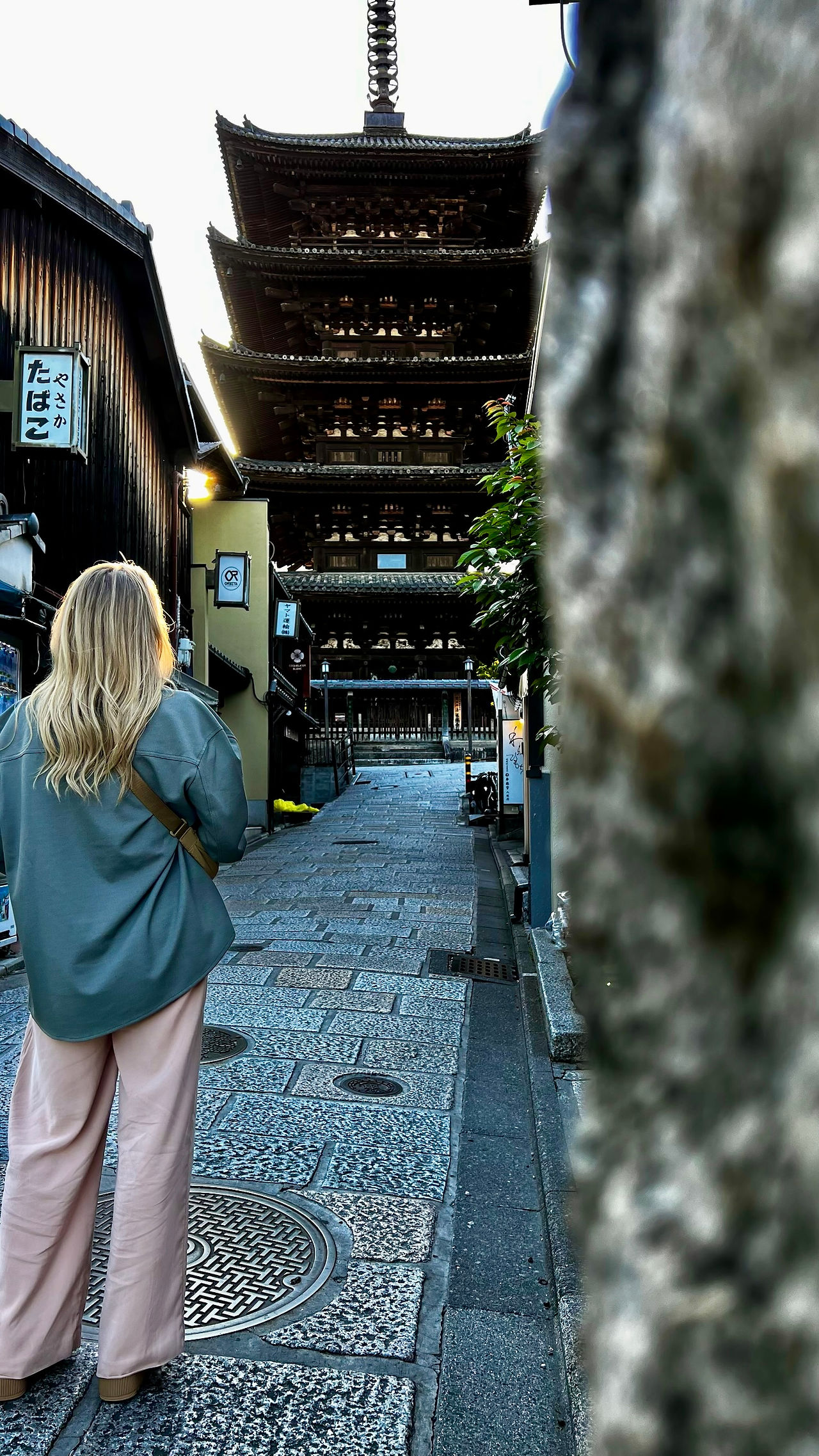 woman poses in front of pagoda on street of gion in kyoto japan