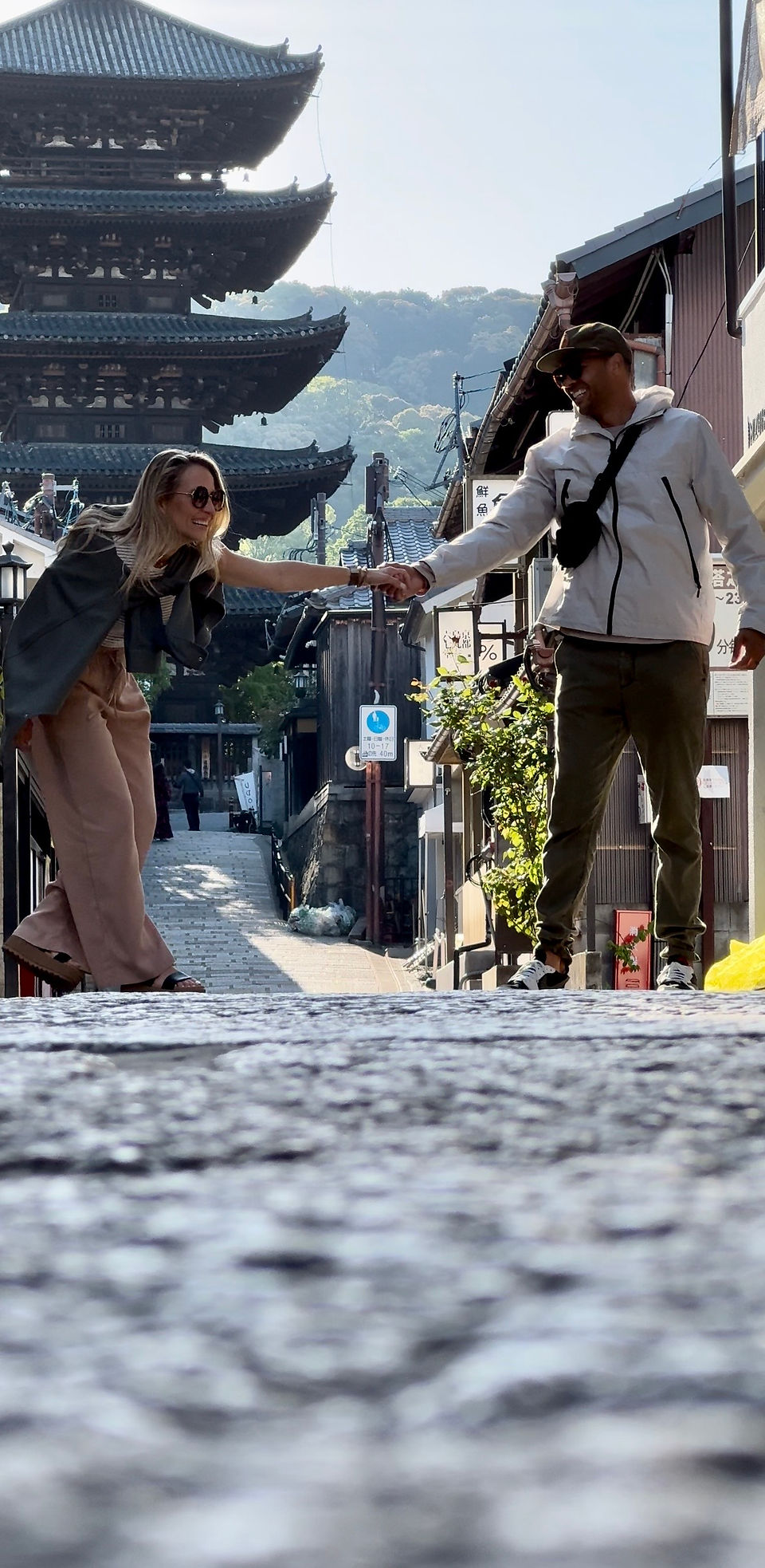 couple poses in front of pagoda on street of gion in kyoto japan