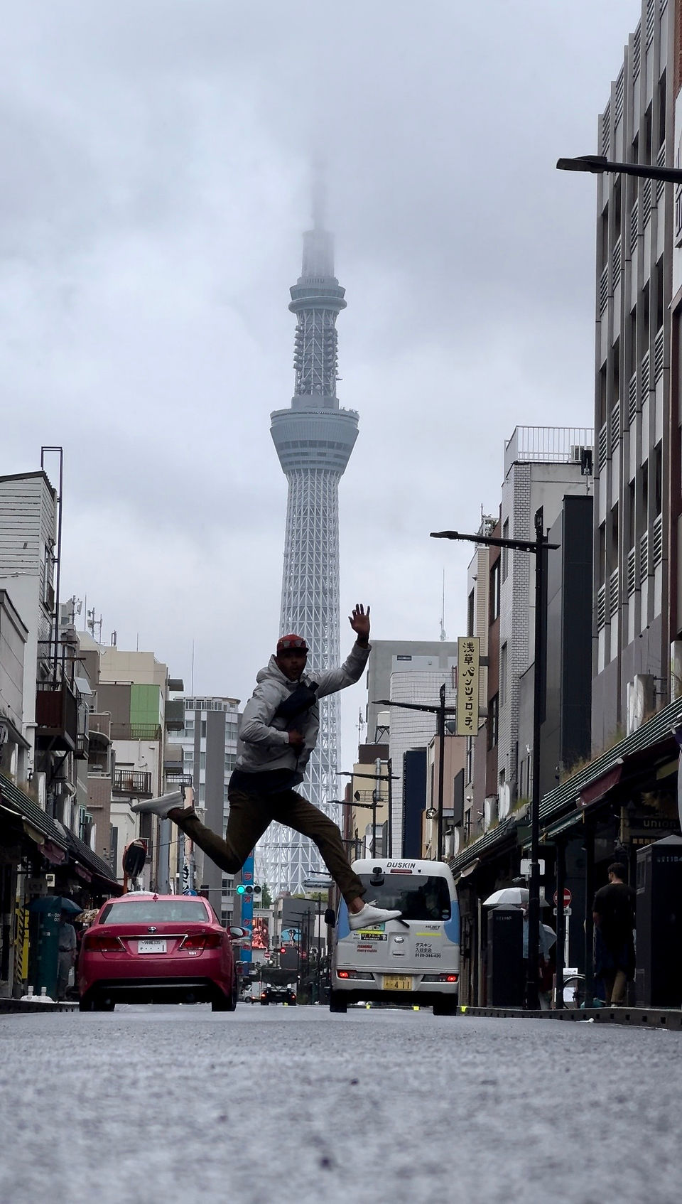 man leaps in air for picture in tokyo street