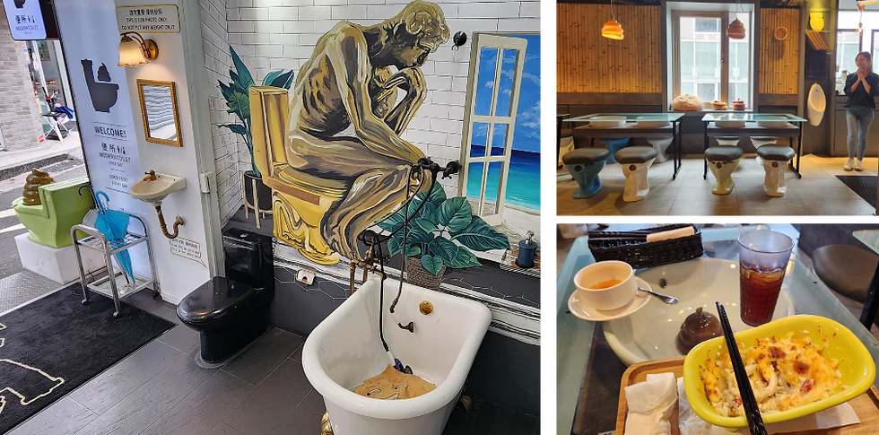 Restaurant with bathroom-themed decor, mural of thinker on toilet, toilet seat chairs, and food on a glass table. Bright and whimsical.