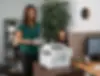 TTS team member assisting a customer at a business printer station in an office setting