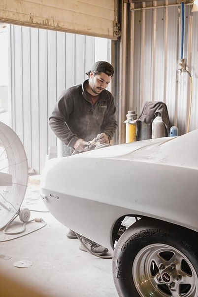 Photograph - Auto body tech bodyworking a 69 Camaro