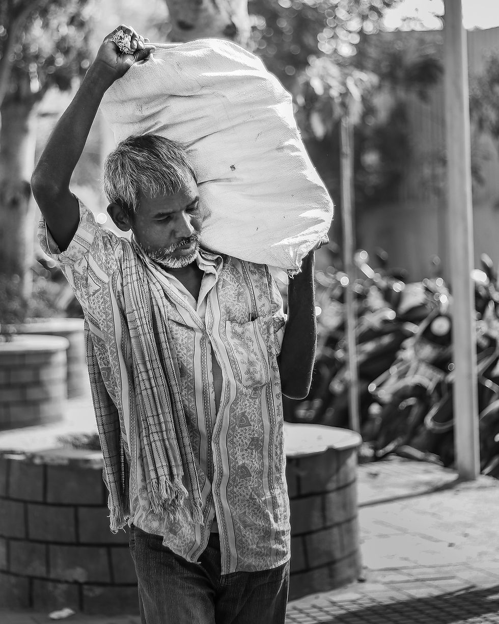 A man carrying a heavy load in a bag