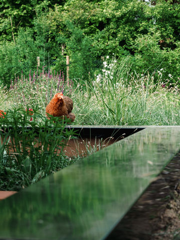 Tuin met zitput in cortenstaal en bloemenborder