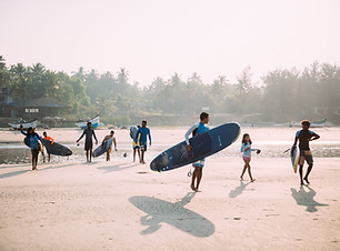 A family is ready to go surfing into the sea with surf boards at mandrem beach