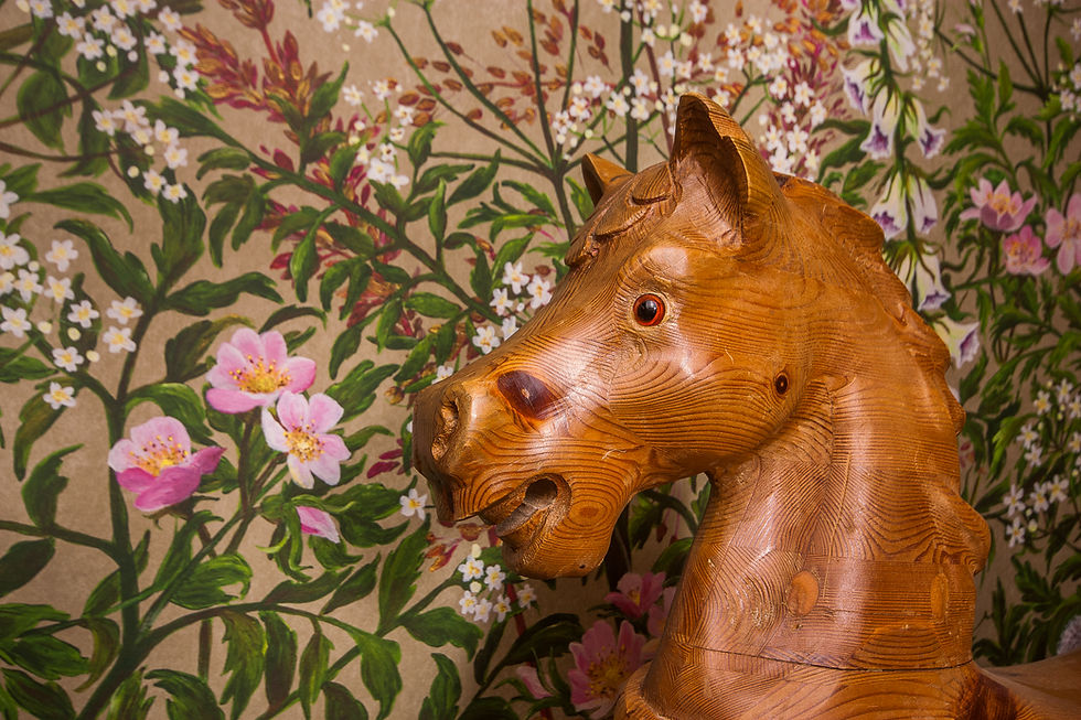 Thumbnail: rocking horse head in front of floral wallpaper