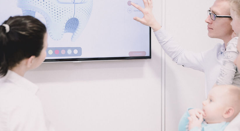 Parent speaking with pediatric specialist about baby helmet therapy.