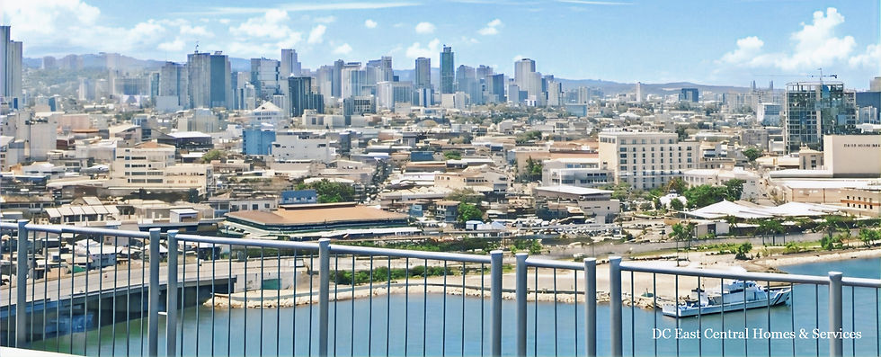 Cebu City skyline viewed from the Cebu-Cordova Link Expressway (CCLEX) with buildings, roads, and coastal areas visible.