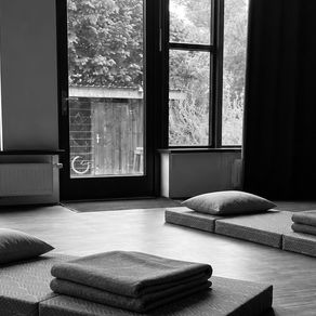 Ruhiger Praxisraum in Bremen mit Matten, Kissen und Fenster zum Grünen — Ort für Atemarbeit und Gespräche.
