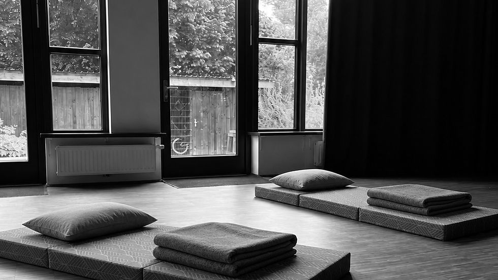 Ruhiger Praxisraum in Bremen mit Matten, Kissen und Fenster zum Grünen — Ort für Atemarbeit und Gespräche.