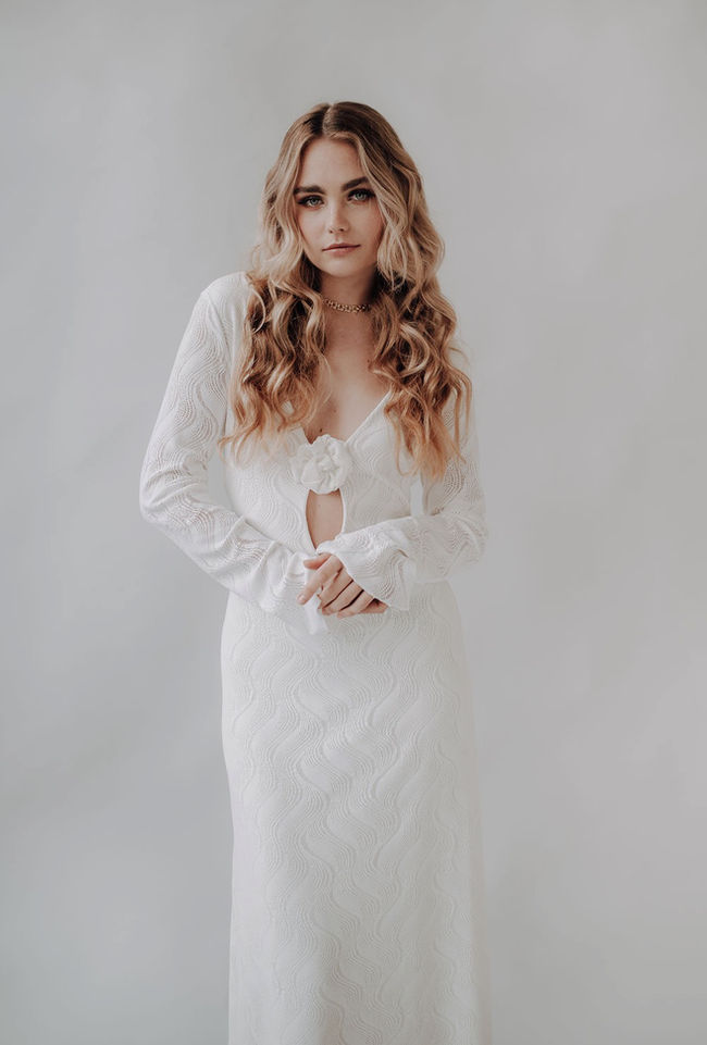 Brautkleid mit langen Ärmeln aus Stretch Spitze mit Cut-Out Ausschnitt und Stoffblüte