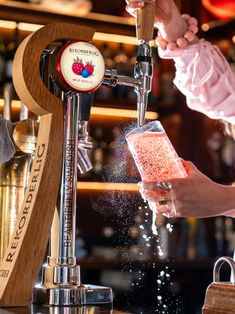 Rekorderlig cider being poured into a glass at a bar.