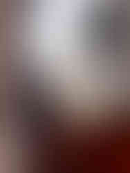 A close up of the bottom corner of a monte carl beer bottle. The bottle has water droplets all over it