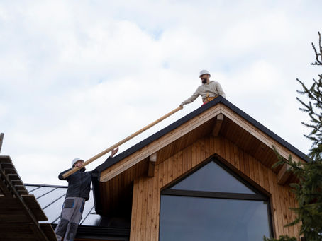 Two people fixing the roof