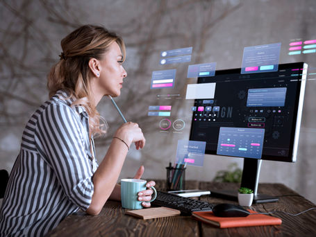 a woman designing a website while holding a coffee mug
