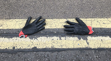 Image of gloves lying in the road over double yellow lines symbolizing 'lost' patients with medically unexplained symptoms.