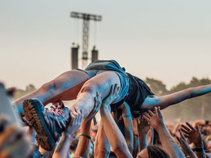 Festivalbesucher wird beim Crowdsurfing von der Menge getragen – ein Moment voller Musik, Freiheit und Gemeinschaft.