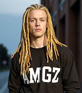 A white male with blond dreadlocks wearing a long sleeved t-shirt with the letters AMGZ.jp
