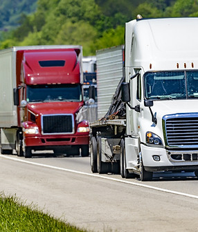 A solid line of eighteen-wheelers barrel down an interstate highway in Tennessee. Heat wa