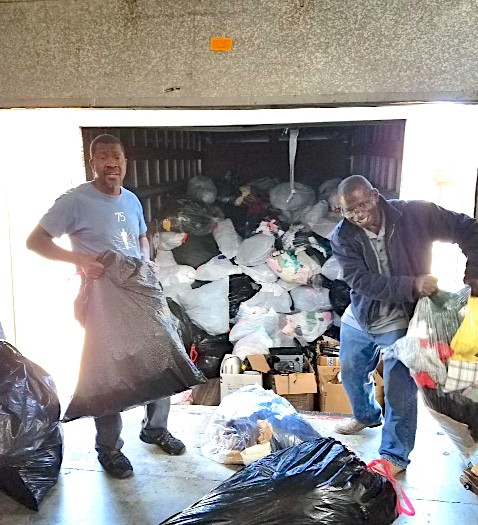 William ( on the left ) picking up the recycle clothing at the Free General Store Distribution Center