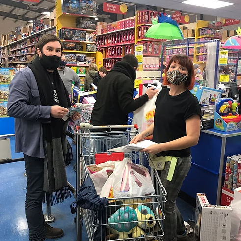 Rachel and male volunteer at the checkout of a toyshop after buying the Christmas gifts.