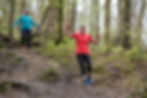 runners downhill woodland