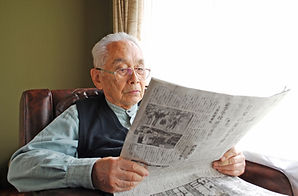 高齢者が新聞を見てる