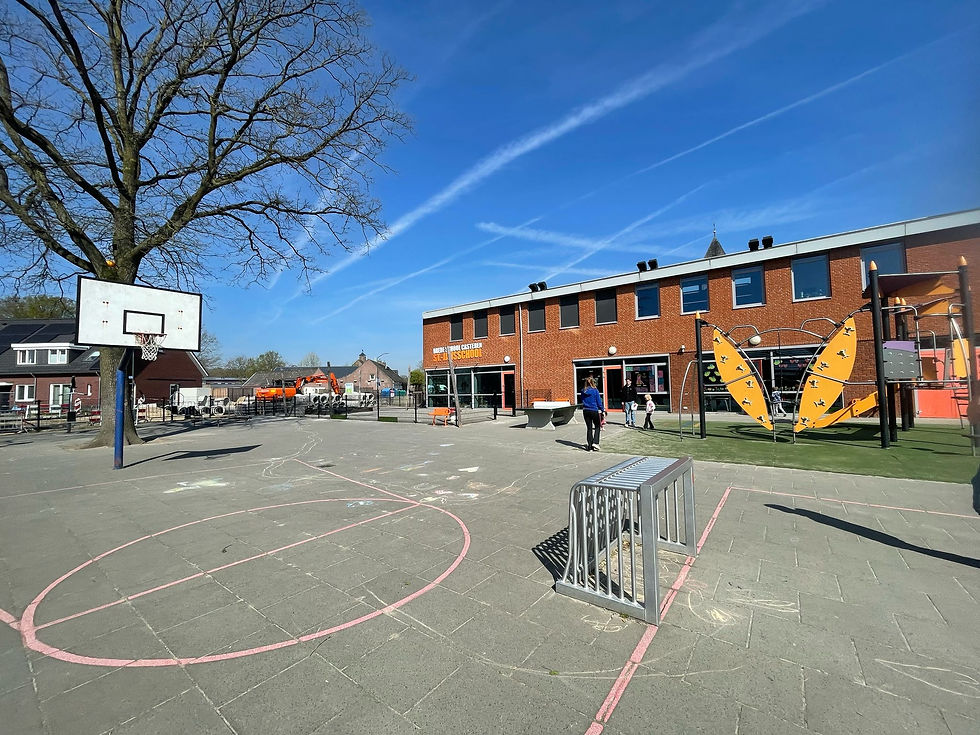 Versteend schoolplein van de St.-Jansschool in Casteren met betegeld speelveld, basketbalpaal en speeltoestellen vóór de vergroening.