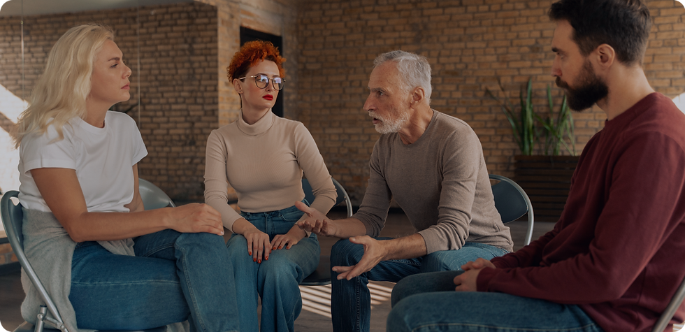 Four people in a circle discussing issues. Conversation taking place during therapy session.