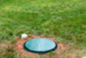 A riser lid at grade on top of a septic tank