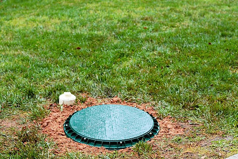 A riser lid at grade on top of a septic tank