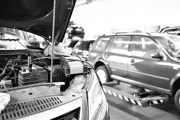 cars in a garage with the bonnet propped open