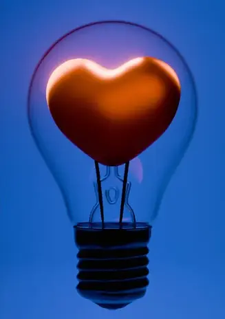 Une ampoule contenant un coeur sur fond bleu pour symboliser l'ingéniosité et l'humain dans le leadership
