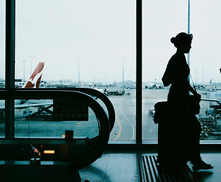 Silhouette of a woman with suitcase at a