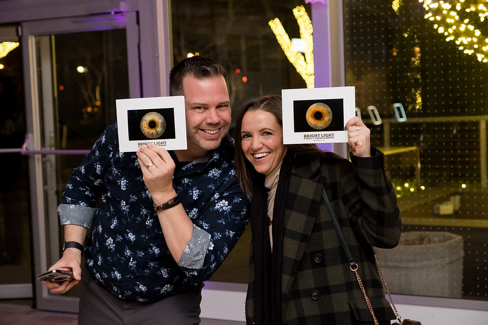 Guests holding Bright Light Events branded Iris photography prints at a corporate event — Bright Light Events and Entertainment