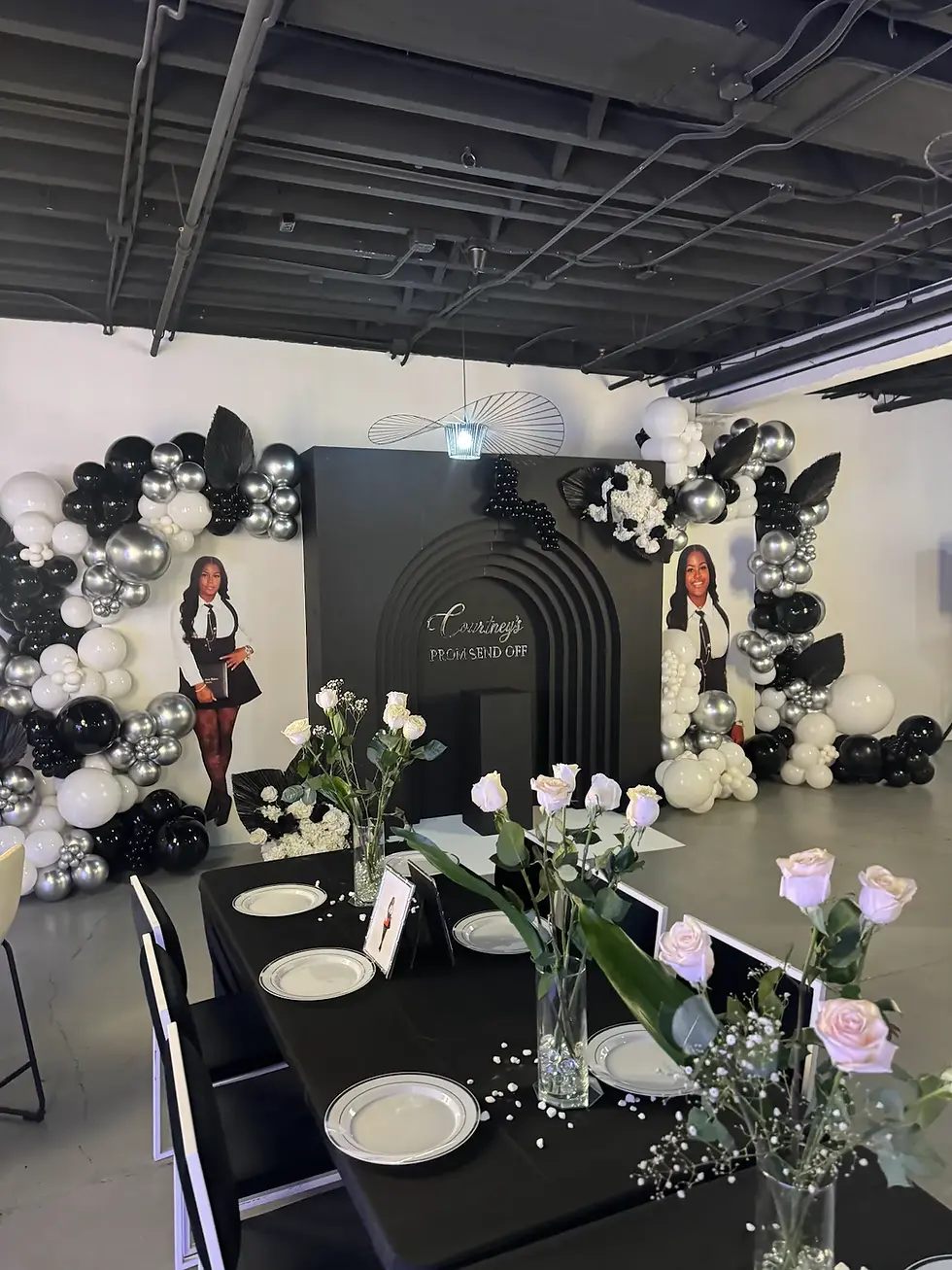 Black and silver prom send-off setup with custom arch backdrop and life-size cutouts at The Fulton West