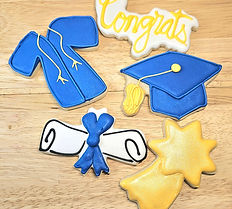 Custom royal icing graduation sugar cookies in blue and gold shaped like a graduation cap, diploma scroll, gown, and star with "Congrats" lettering