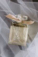 Perfume bottle with "Chloé" text, clear glass, and beige ribbon. Set against soft, white tulle fabric, conveying elegance and luxury.