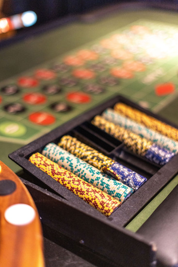 Close-up of a casino chip tray beside a roulette wheel on a green felt roulette table at a Chicago event