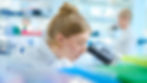 A research scientist peers into a microscope.