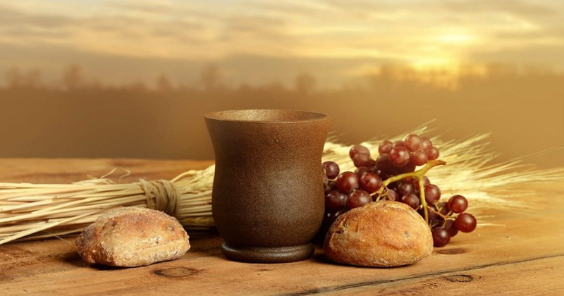 Vessell of wine and bread rolls, grapes and sheaf of wheat