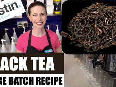 A smiling woman in a pink shirt, known as Bubble Tea Kristin, stands by bottles, a pile of black tea, and a metal spout. Text: Kristin, Bubble Tea Expert, Black Tea Large Batch Recipe.