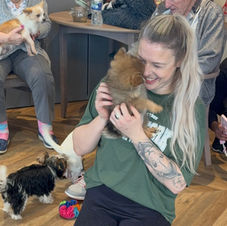 Smiling woman with a small fluffy pomeranian dog.