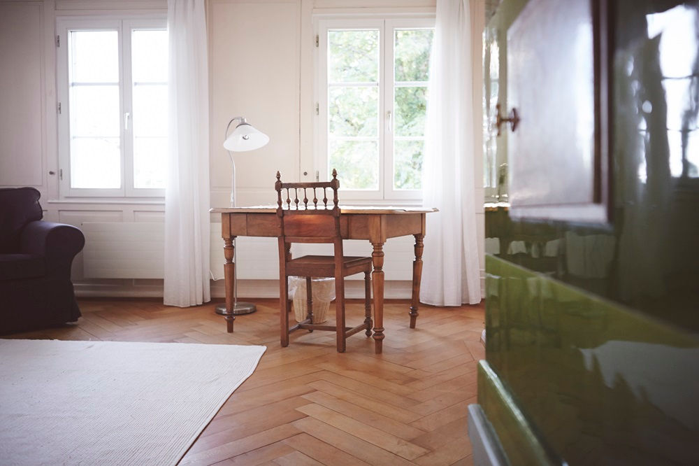 Zimmer mit Holztisch und Kachelofen