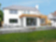Here’s an ideal accessible image description (alt text) tailored for Google and screen readers, optimized for both clarity and SEO: Alt Text: "Modern rear house extension with white render and vertical timber cladding, featuring large glass sliding doors opening onto a tiled patio with minimalist outdoor furniture.