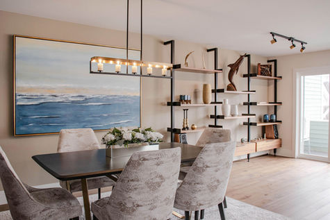 Chic dining room with modern table set, elegant chandelier, and custom shelving.
