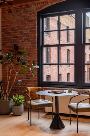 RailSpur Studios brick wall, large window, and small cafe table with custom chairs