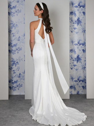 The simple beauty of the Capri dress is in its modern, pared-back design with its slinky satin and clean lines. The dress is fully lined in our softest satin for a luxurious feel on the body. A clever twist of fabric at the neck reveals a subtle keyhole neckline as you move. The statement halterneck bow on the back is revealed as you turn, for an elegant dress full of personality.