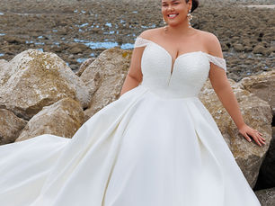 Plus size bride in strapless a-line wedding dress on the beach.