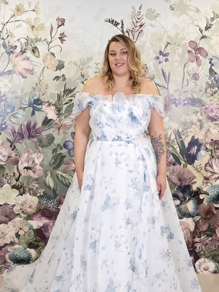 Blue printed wedding dress from Island Bridal. A gentle step away from traditional gowns, our subtle water colour print florals offer romance and femininity wrapped up in a fairytale. A gentle blouson effect over the bustline into delicate bardot shoulder straps keep the look soft and gentle whilst our unparalleled structure and support within the gown give the bride an amazing fit and confidence all day long.